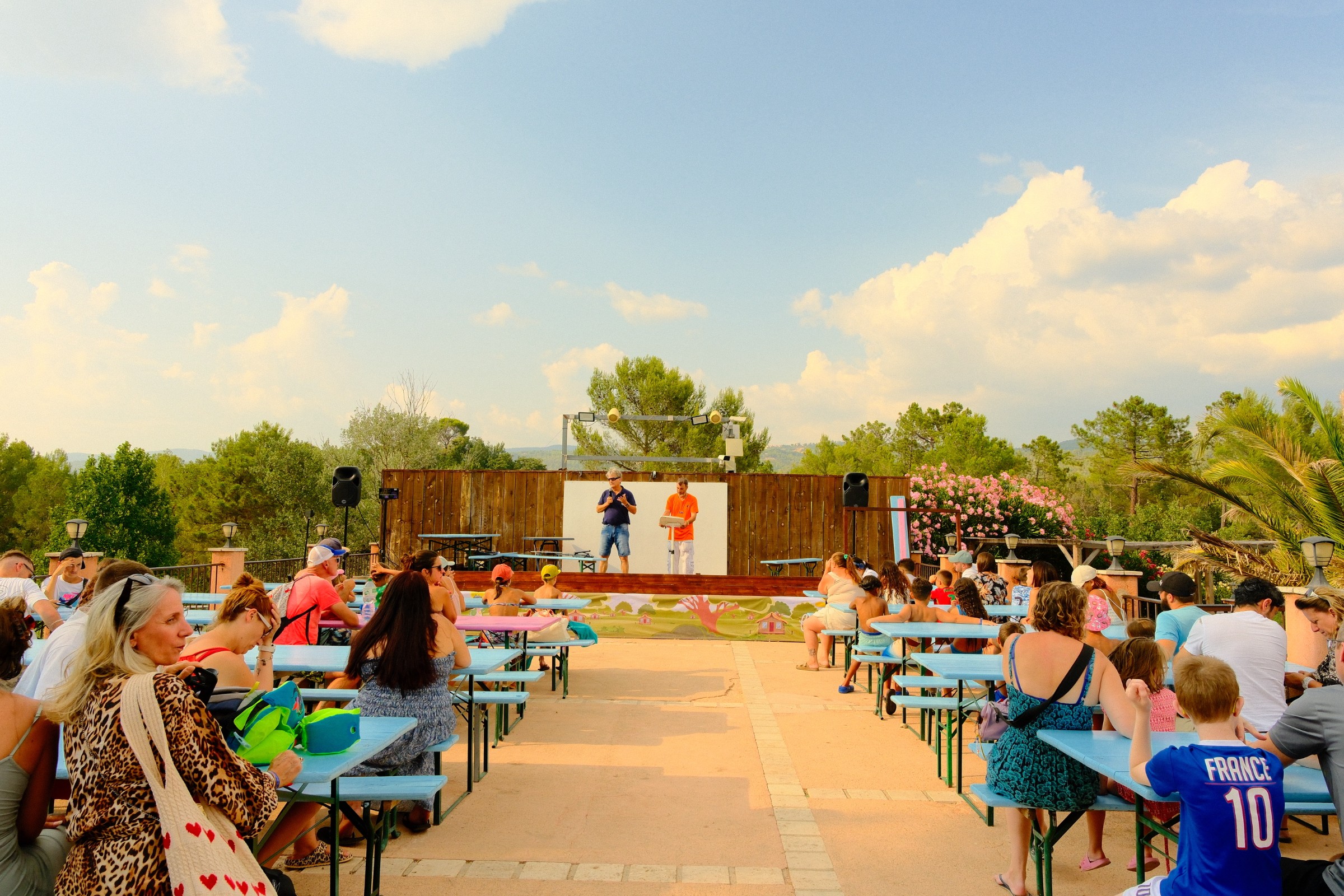 Spectacle en soirée avec public assis à tables face à la scène au camping Le Var