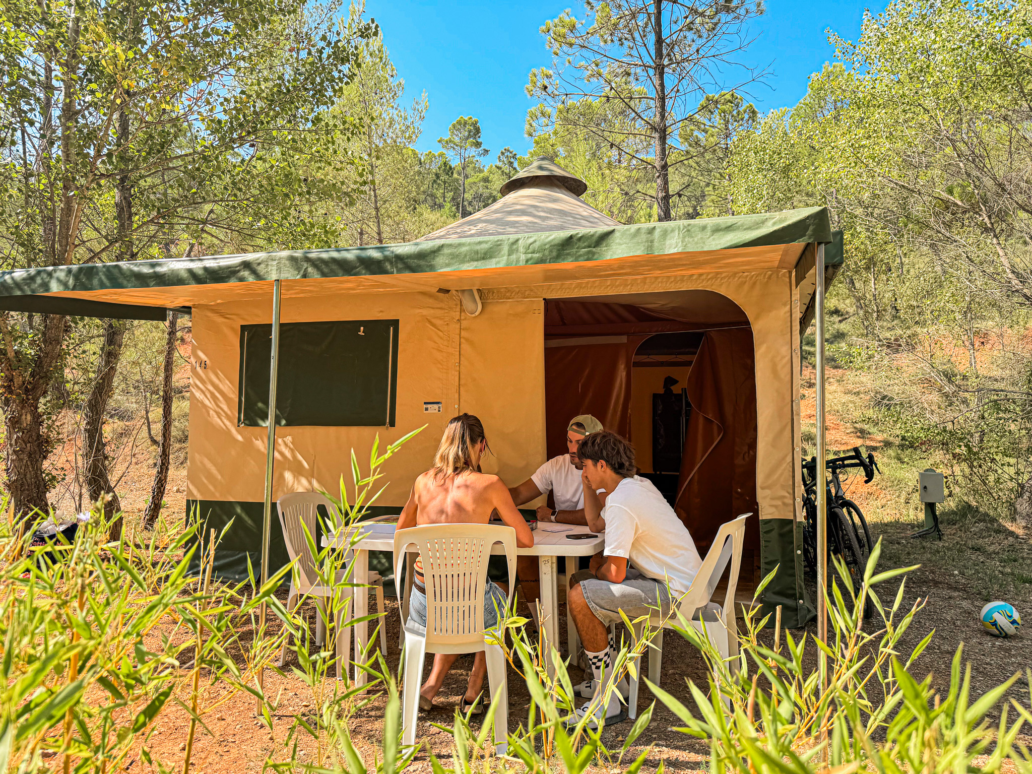 Mobil-home orange avec terrasse ombragée et salon de jardin dans le camping du Var