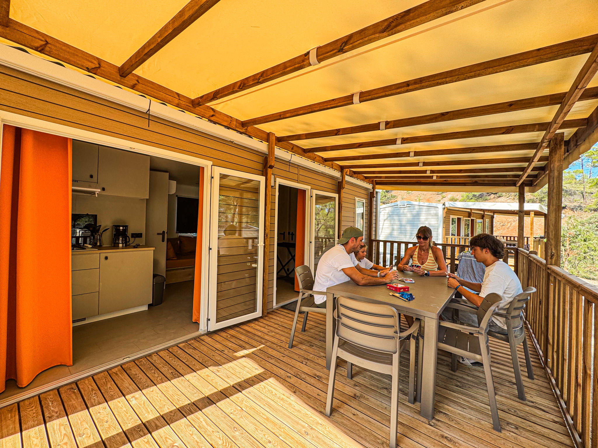 Famille jouant sur la terrasse chauffée d'un mobil-home à Villecroze-les-Grottes