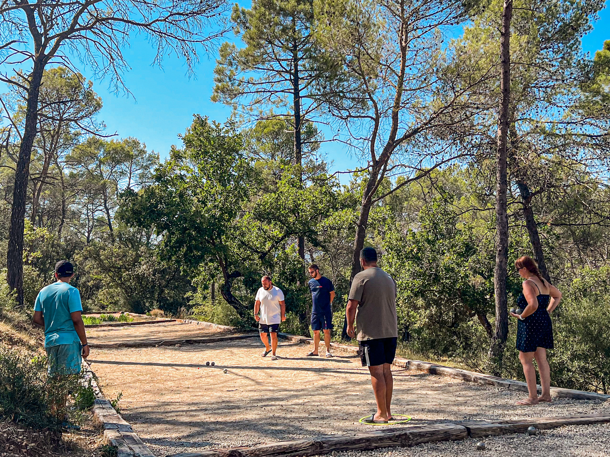 Groupe de joueurs en partie de pétanque au camping de Villecroze-les-Grottes.