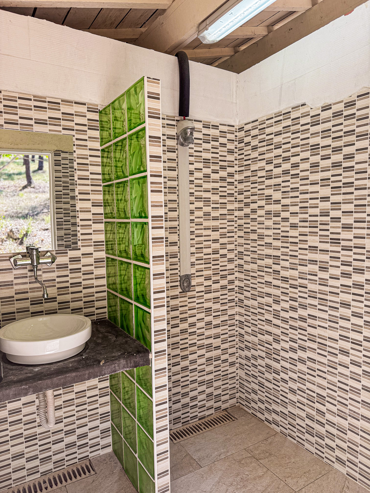 Salle d'eau moderne avec douche et carrelage à motifs dans les sanitaires de Villecroze-les-Grottes.