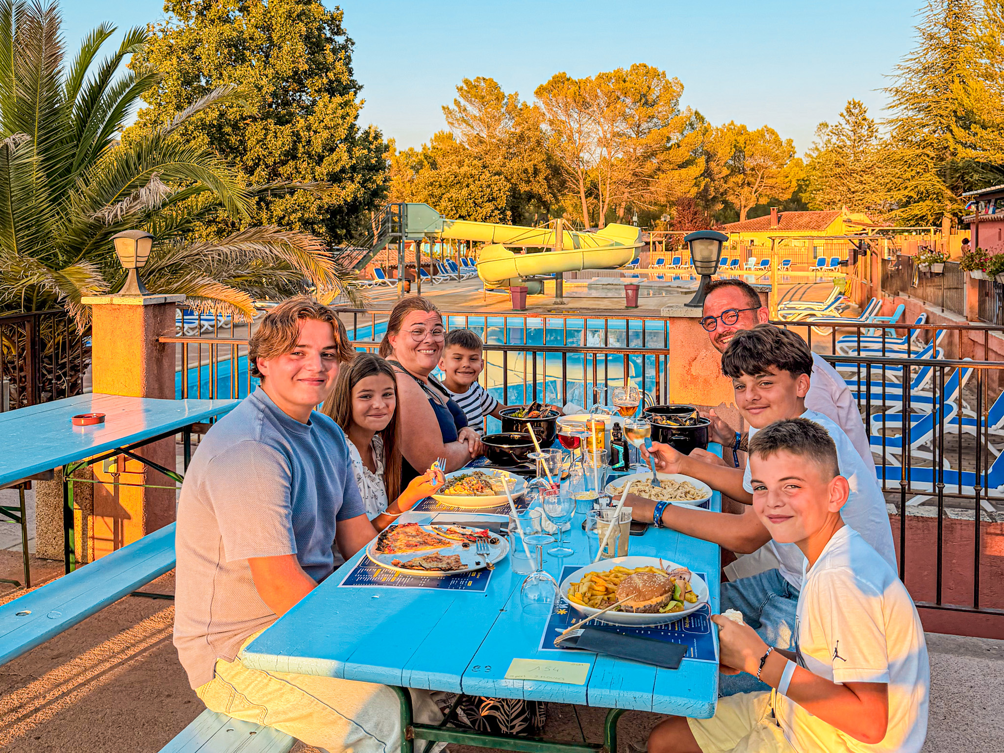 Famille qui dîne sur la terrasse du restaurant avec vue sur la piscine à Villecroze-les-Grottes