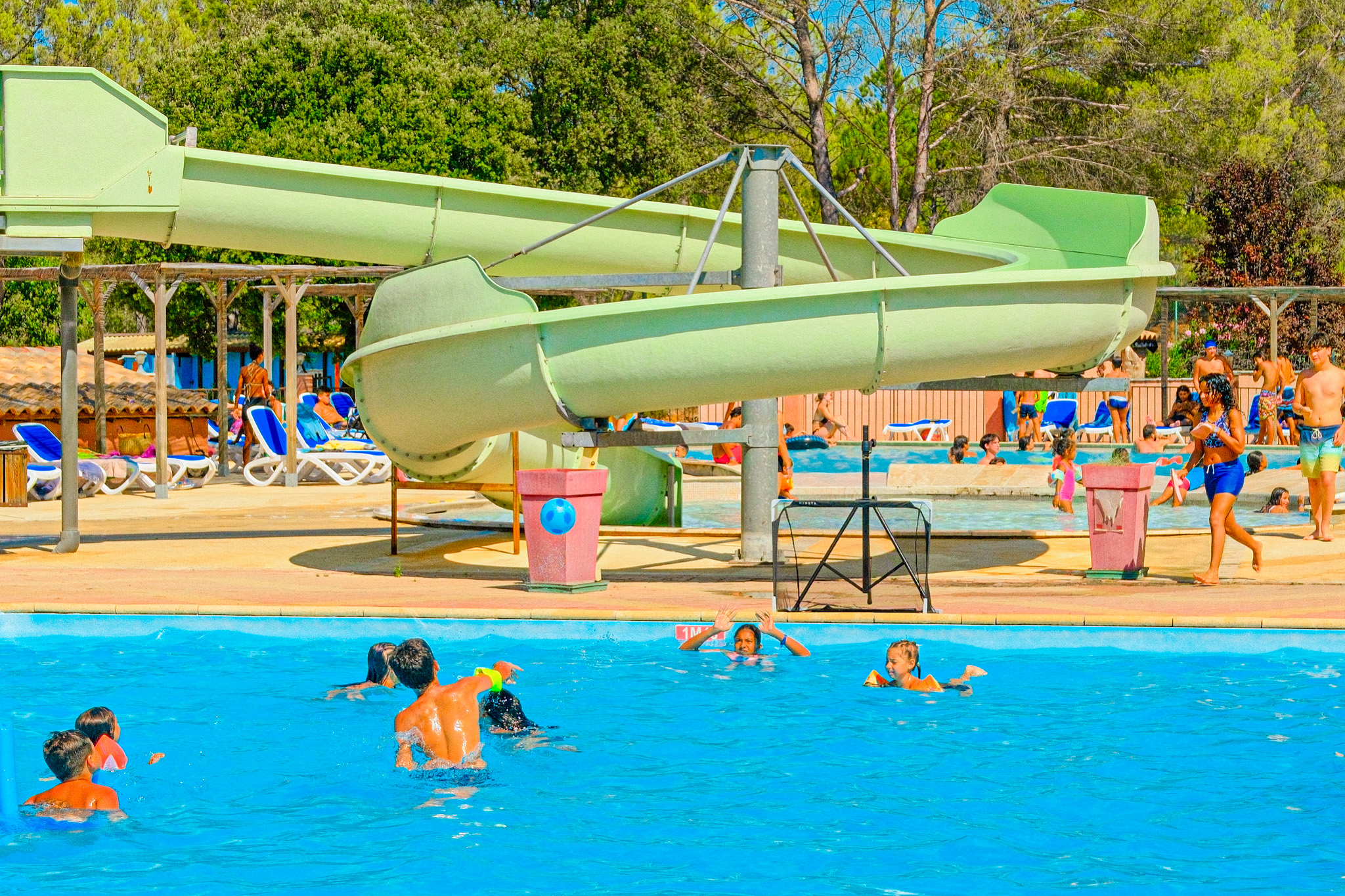 Toboggan aquatique vert accueillant enfants en gilets de sauvetage à Villecroze-les-Grottes