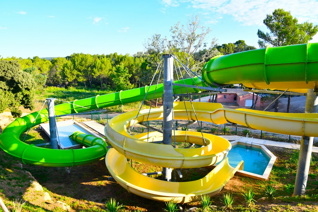 Toboggans aquatiques vert et jaune offrant glissades dans un parc aquatique au Var